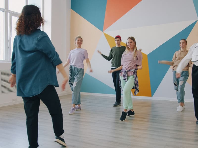 Groupe d’adultes qui suivent un atelier de danse dans un studio coloré